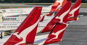 Row of Qantas aircraft tails at Melbourne Airport with red kangaroo livery, parked at the gate