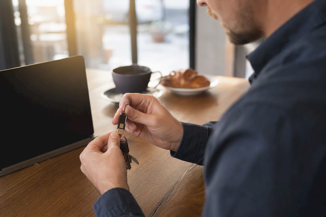 Hands removing physical security key from key ring