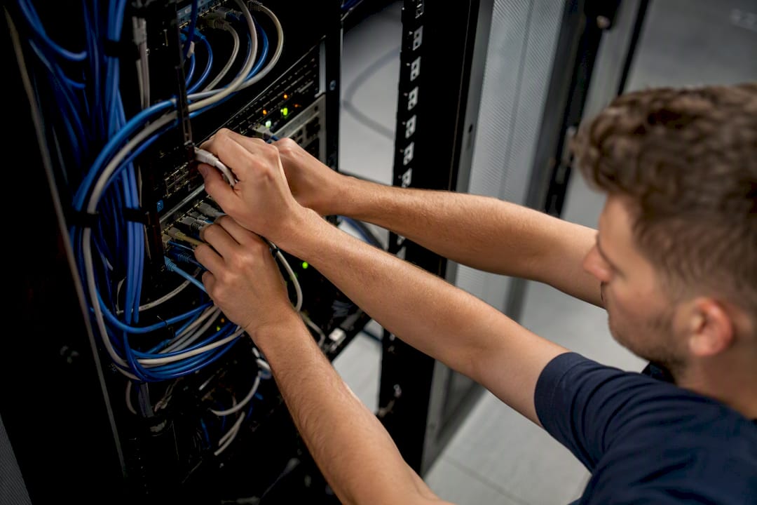 Technician hands connecting security cables in server rack