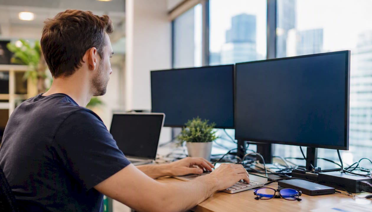 Hands typing security scan on dark keyboard in office