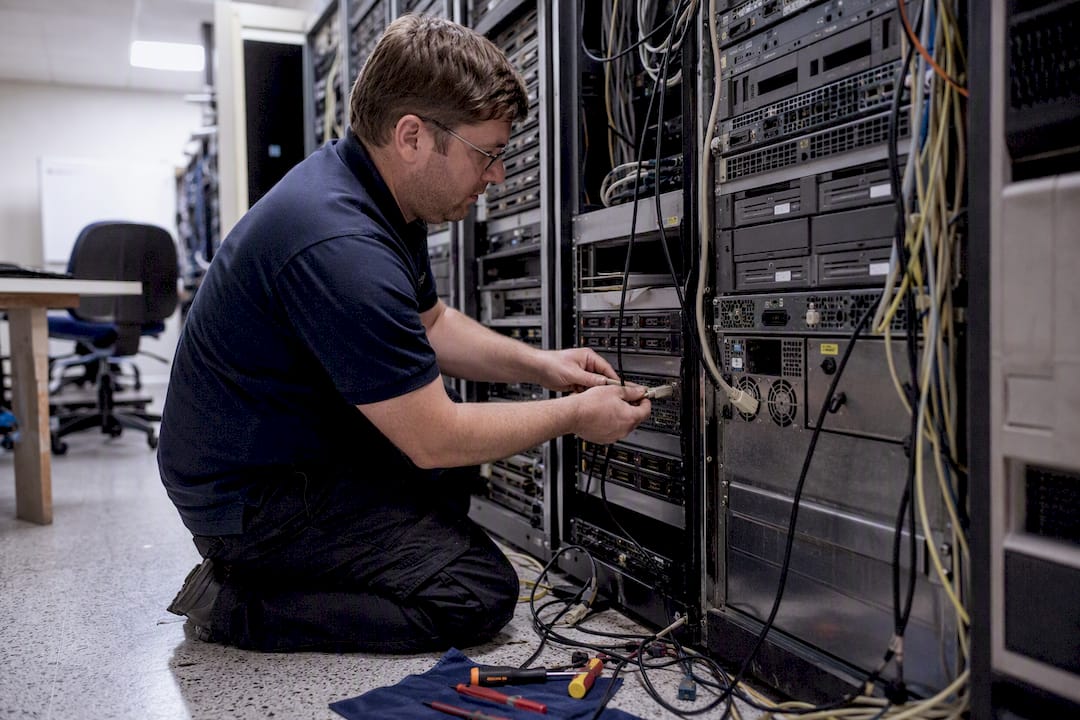 Hands unplugging cable from old server