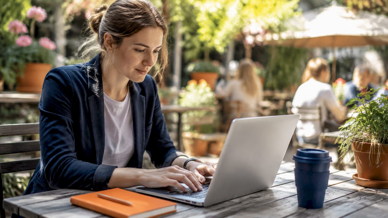Hands typing on laptop in café for reporting