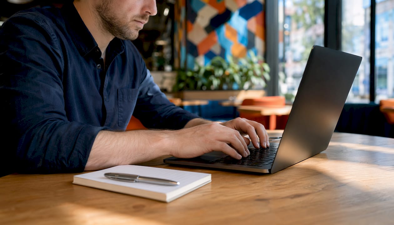 Hands typing on keyboard with security manuals